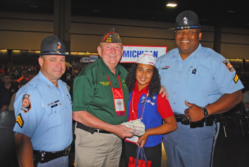 Department of Michigan presenting donation to Buddy Poppy Child along with a very large State Trooper as bodyguard